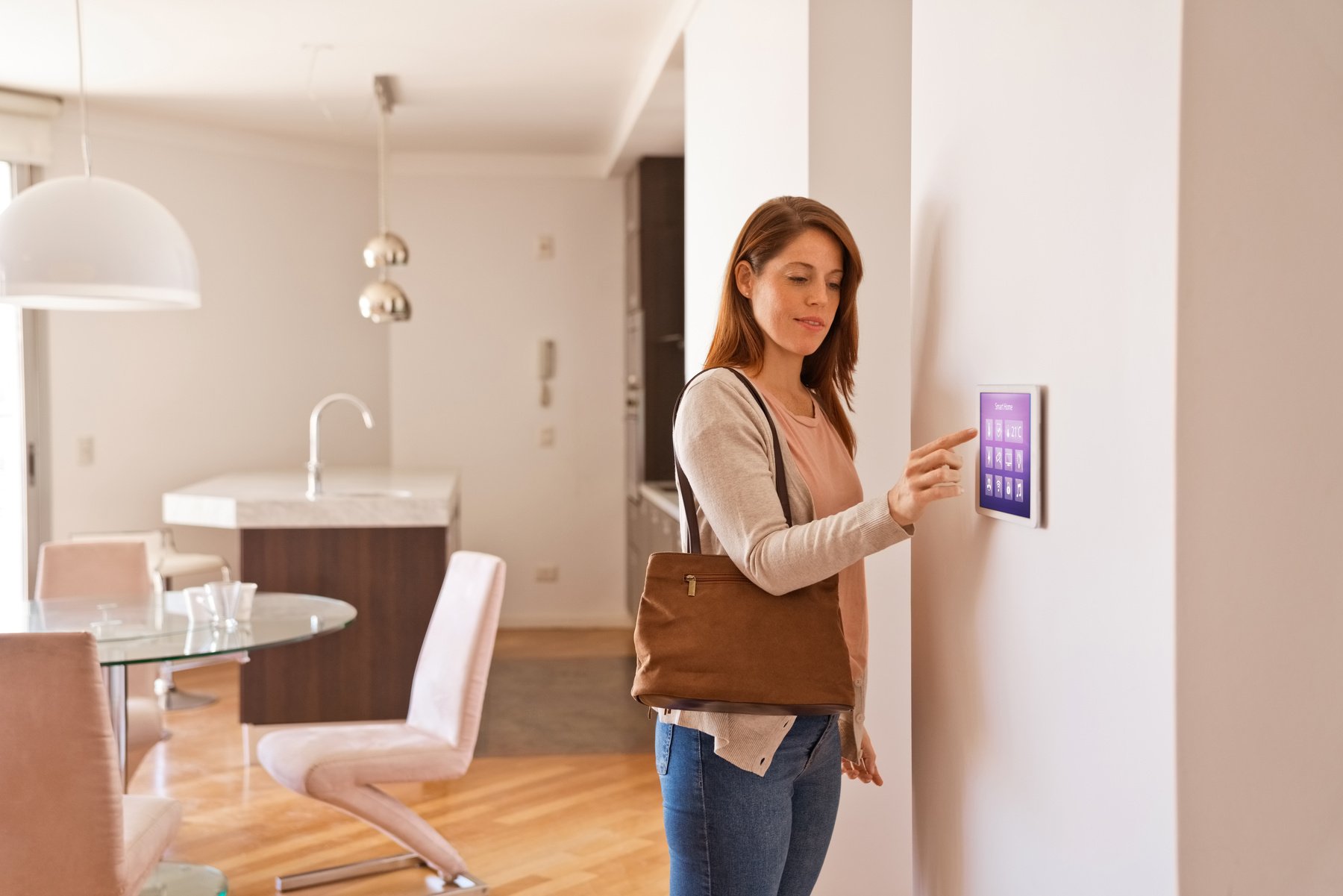 Woman activating smart home security system before leaving